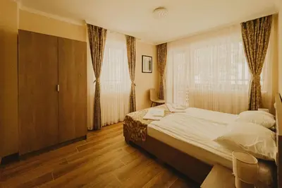 a bedroom with a large bed and a window at Хижа Марциганица in Asenovgrad