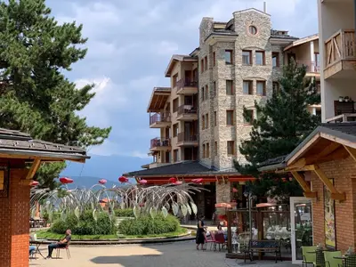 a building with a clock tower on the side of a street at Studio 5 in Pirin Golf in Razlog