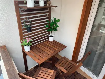 a table and two chairs on a balcony with plants at Studio 5 in Pirin Golf in Razlog