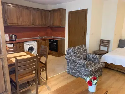 a living room with a kitchen and a dining room at Studio 5 in Pirin Golf in Razlog