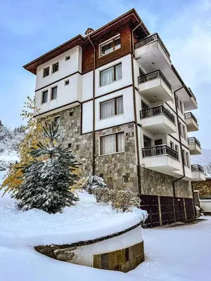 a building with snow in front of it at РЕЛАКС - апартамент 1 in Chepelare