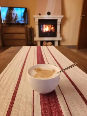 a bowl of coffee on a table with a fireplace at РЕЛАКС - апартамент 1 in Chepelare