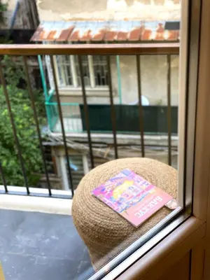 a book sitting on top of a hat in a window at Este Apart Historical Center in Sofia