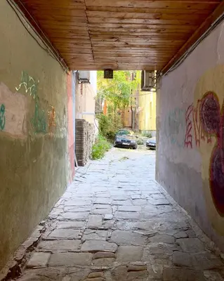 an alley way with graffiti on the side of a building at Este Apart Historical Center in Sofia
