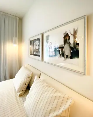 a bedroom with a bed with two pictures on the wall at Este Apart Historical Center in Sofia