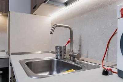 a kitchen counter with a sink with a faucet at Cozy 2-bed Apartment in Plovdiv