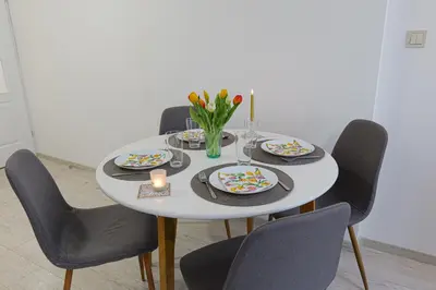 a white table with chairs and plates and a candle at Tulip Dreamland in Sofia