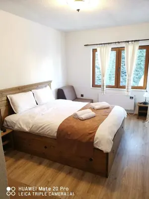 a bedroom with a large bed with two towels on it at Вила 5 - Планински перли in Stoykite
