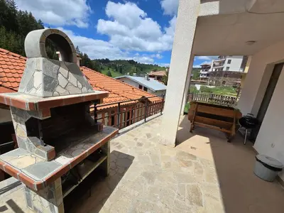 a balcony with an outdoor oven on a building at Вила 5 - Планински перли in Stoykite