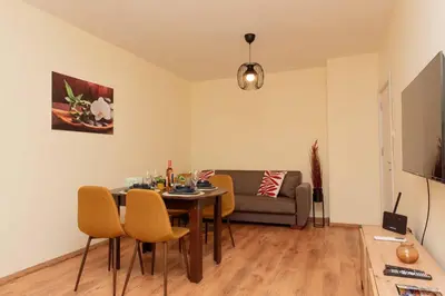 a living room with a table and chairs and a couch at Momento Apartment in Kyustendil