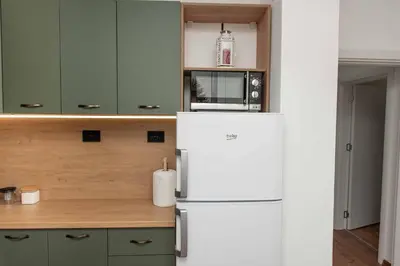 a kitchen with a white refrigerator and a microwave at Momento Apartment in Kyustendil
