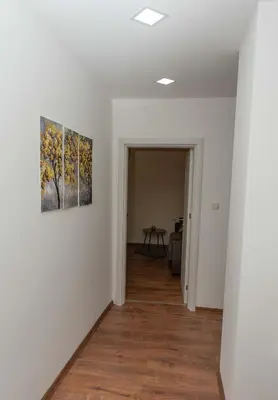 a hallway with white walls and a painting on the wall at Momento Apartment in Kyustendil