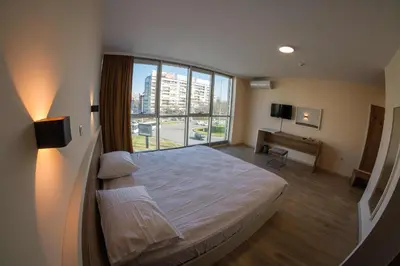 a bedroom with a bed and a large window at HOTEL BAYKO in Plovdiv
