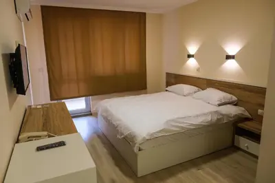 a bedroom with a bed and two lights on the wall at HOTEL BAYKO in Plovdiv