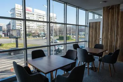 a room with tables and chairs and a large window at HOTEL BAYKO in Plovdiv