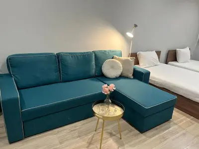 a blue couch in a living room with a table at Nomadic Travelers Apartment in Sofia