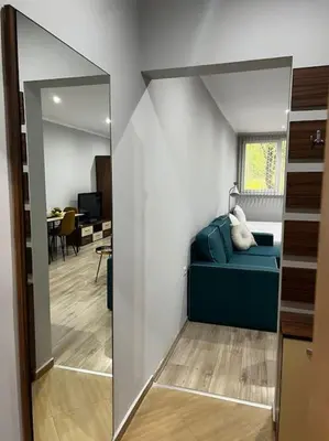 a room with a blue couch and a mirror at Nomadic Travelers Apartment in Sofia