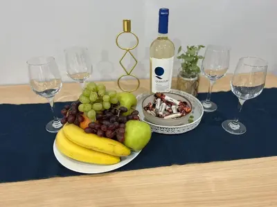 a plate of fruit on a table with wine glasses at Nomadic Travelers Apartment in Sofia