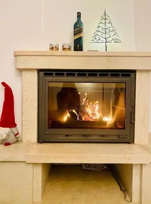 a fireplace with a fire inside of it at Apartment in Complex Monastery 1 in Pamporovo