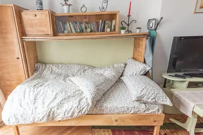 a bedroom with a bed with a shelf on the wall at Centrally Located Vintage Flat in Sofia