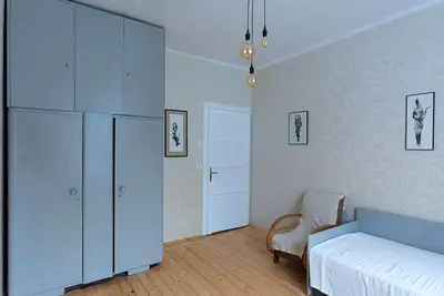 a bedroom with a bed and a cabinet and a chair at Centrally Located Vintage Flat in Sofia