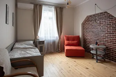 a bedroom with a bed and a chair and a brick wall at Centrally Located Vintage Flat in Sofia