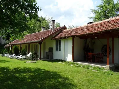 a small white house with a red roof at Roden Dom Holiday Home in Apriltsi