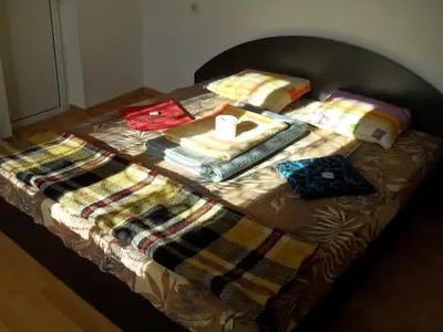a bed with a pile of blankets and pillows on it at Roden Dom Holiday Home in Apriltsi