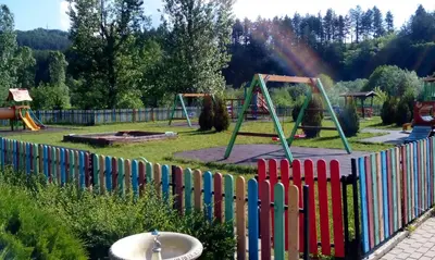 a fence in a park with a playground at Roden Dom Holiday Home in Apriltsi