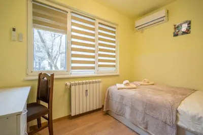 a bedroom with a bed and a chair and a window at Top Location Central New & Spacious 3 BDR apt Medical Academy in Sofia