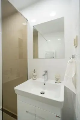 a white bathroom with a sink and a mirror at Top Location Central New & Spacious 3 BDR apt Medical Academy in Sofia