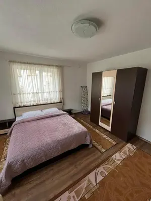 a bedroom with a large bed and a mirror at Къща за гости Горски рай in Smilyan