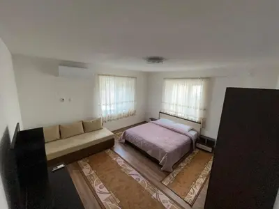 a bedroom with a bed and a couch at Къща за гости Горски рай in Smilyan