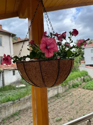 a flower pot hanging on a porch at Къща за гости Горски рай in Smilyan