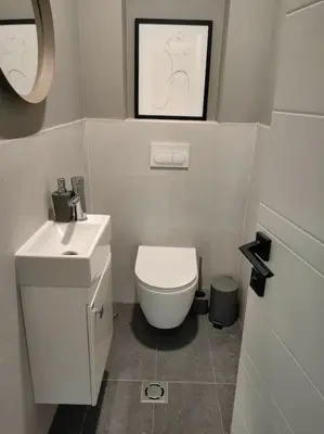a bathroom with a white toilet and a sink at The Courtyard 2Bdrm Apartment in Sofia