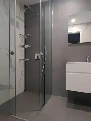 a bathroom with a glass shower and a sink at The Courtyard 2Bdrm Apartment in Sofia