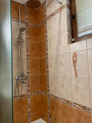 a shower in a bathroom with a glass door at Vessy’s apartment in Smolyan