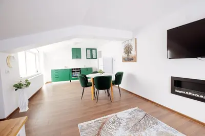 a living room with a table and green chairs at GreenBoxApartment in Kyustendil