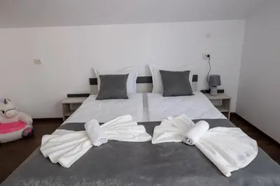 a white bed with two white towels on it at GreenBoxApartment in Kyustendil