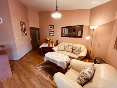 a living room with two couches and a table at Marina Apartment - Mountain View in Bansko