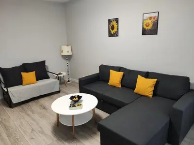 a living room with a couch and a table at Maya's Airport Apartment in Sofia