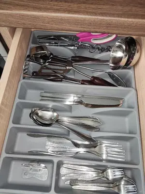 a drawer filled with silver utensils in a drawer at Maya's Airport Apartment in Sofia