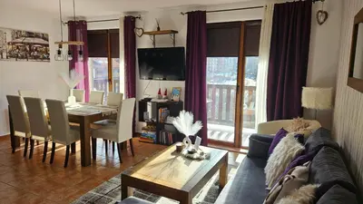 a living room with a couch and a dining room table at Bansko Prespa Ski Penthouse in Bansko