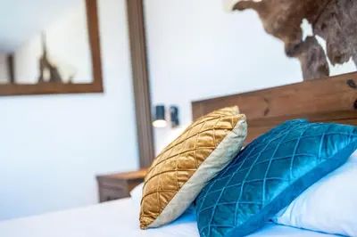 a bed with two blue pillows on it at Private cozy at Alpin Lodge Studio + SPA Complex in Bansko