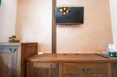 a wooden cabinet with a tv on the wall at Private cozy at Alpin Lodge Studio + SPA Complex in Bansko