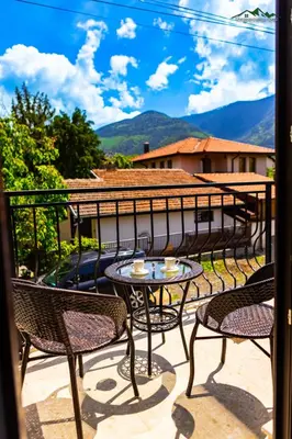 a patio with chairs and a table on a balcony at Докторската къща in Sapareva Banya