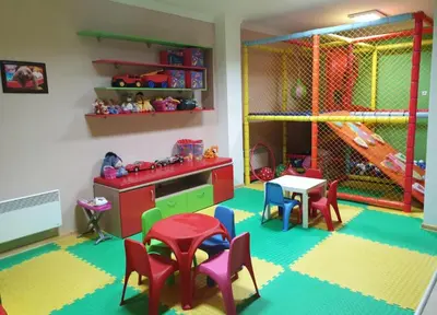 a childs play room with a table and chairs at Grand Monastery Pamporovo Luxury Apartment in Pamporovo