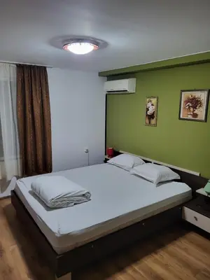 a bedroom with a white bed with a green wall at Solar in Plovdiv