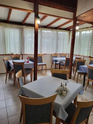 a dining room with tables and chairs and windows at Solar in Plovdiv