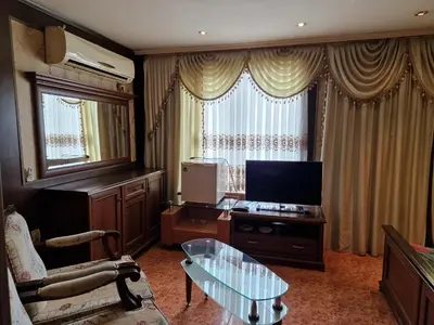 a living room with a glass table and a television at Хотел-ресторант Астория in Pazardzhik